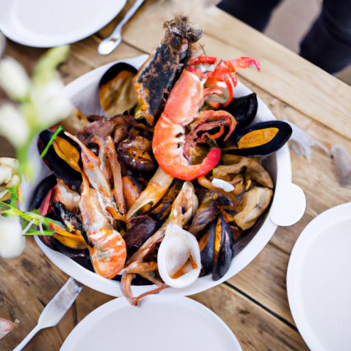 Món hải sản trên đĩa được đặt trên bàn gỗ với bộ đồ ăn đẹp mắt