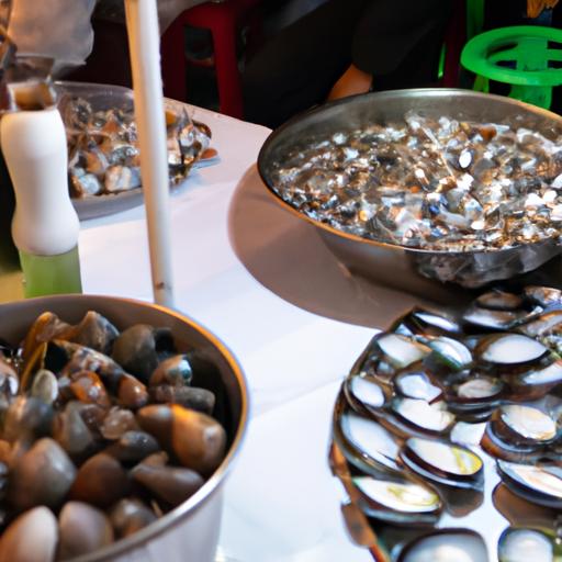 Nhà hàng hải sản đông đúc ở Hà Nội, với các đĩa ốc và sò khác nhau trên bàn ăn.